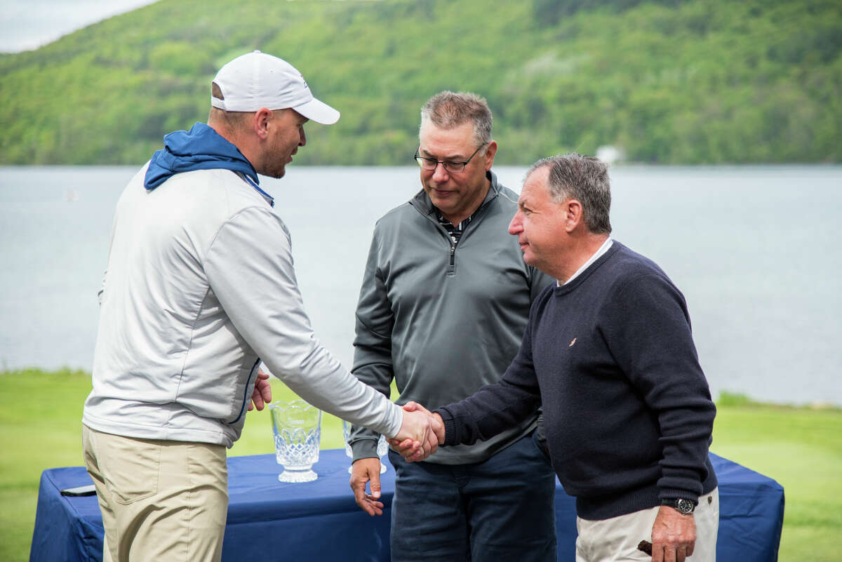New York State Golf Association tournament director Andrew Hickey, left, congratulates the winners of the organization's Four Ball Championship, Matt Clarke, center, of Loudonville, and Bob Rosen.