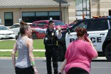 People are helped crossing the street to Uvalde Memorial Hospital, where several people believed to be hurt in a shooting at or near a school are being treated in Uvalde, Texas, on Tuesday, May 24, 2022. A large police presence at the hospital was keeping most people out.
