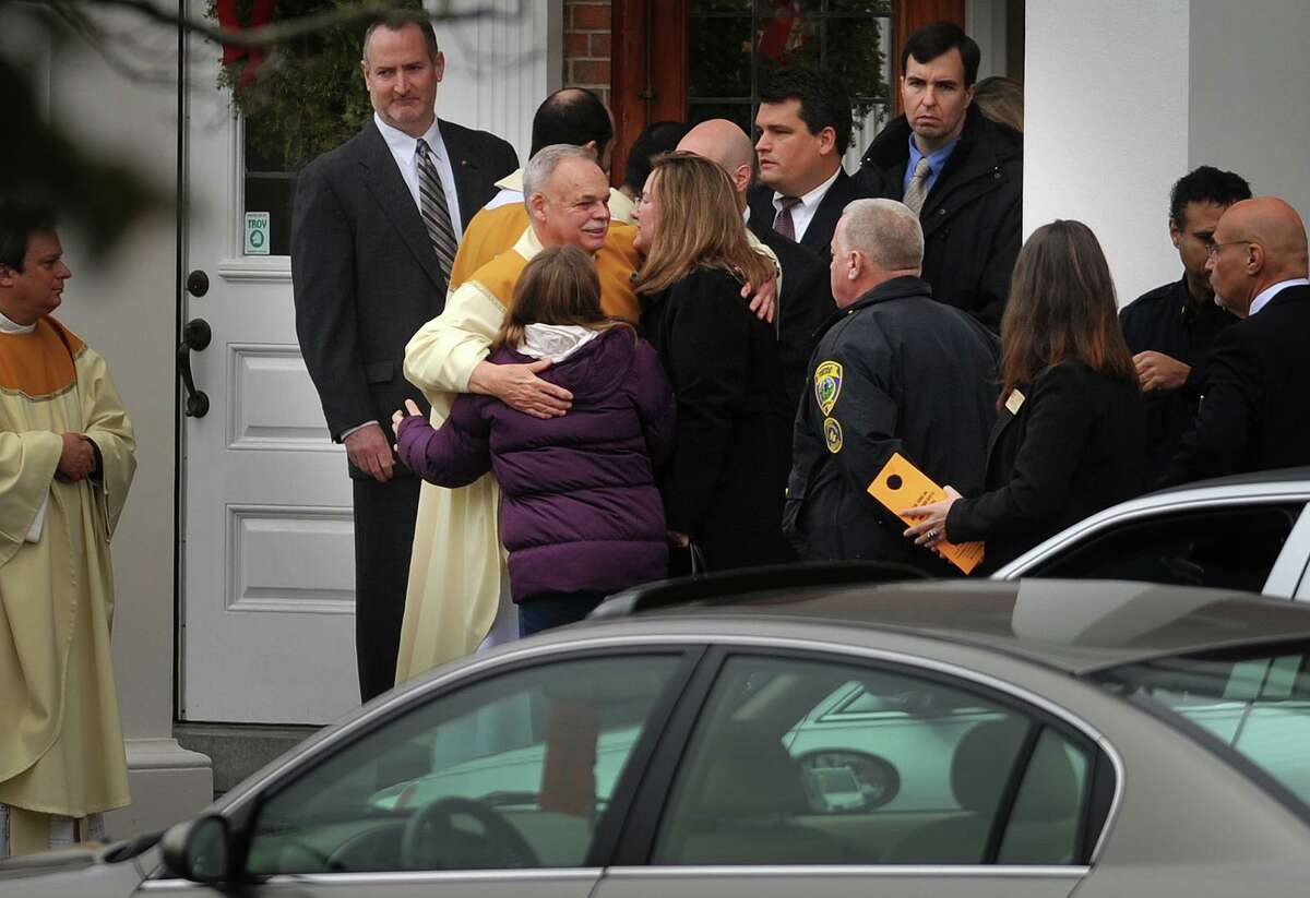 Cindy Mattioli and Anna Mattioli, mother and sister of James Mattioli, one of the students killed in the Sandy Hook Elementary School shooting, embrace clergy following James Mattioli's funeral at St. Rose of Lima Catholic Church in Newtown on Tuesday, December 18, 2012.