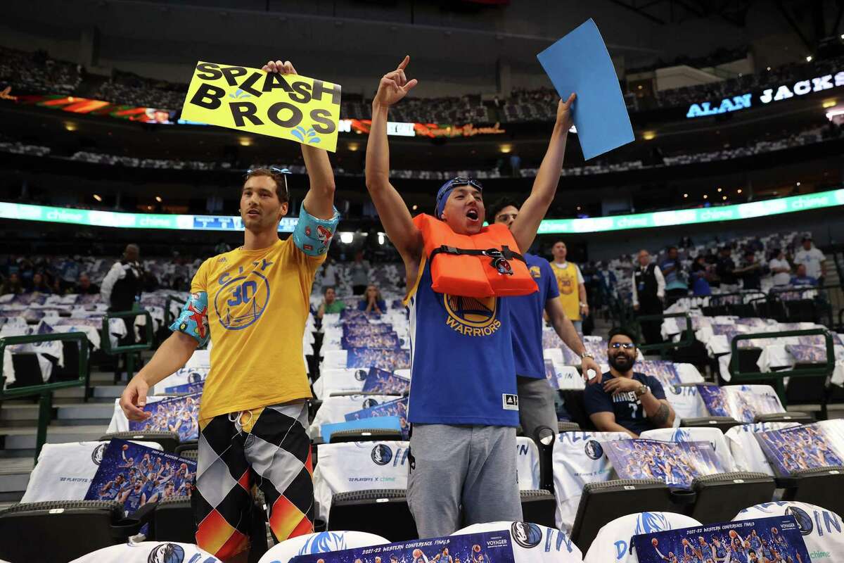 Golden State Warriors’ fans Micah Bristow and and Jon Rompel cheer as Stephen Curry and Klay Thompson warm up before Warriors play Dallas Mavericks in Game 4 of NBA Western Conference Finals at American Airlines Center in Dallas, Texas, on Tuesday, May 24, 2022.