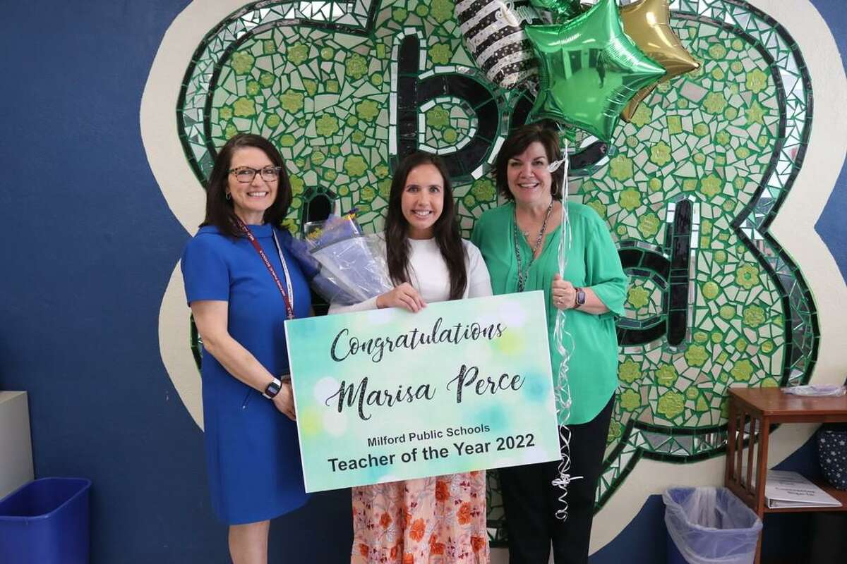 Milford School District Teacher of the Year Marisa Perce, center, is congratulated by Superintendent Anna Cutaia, left, and Calf Pen Meadow principal Jamie Whitaker.