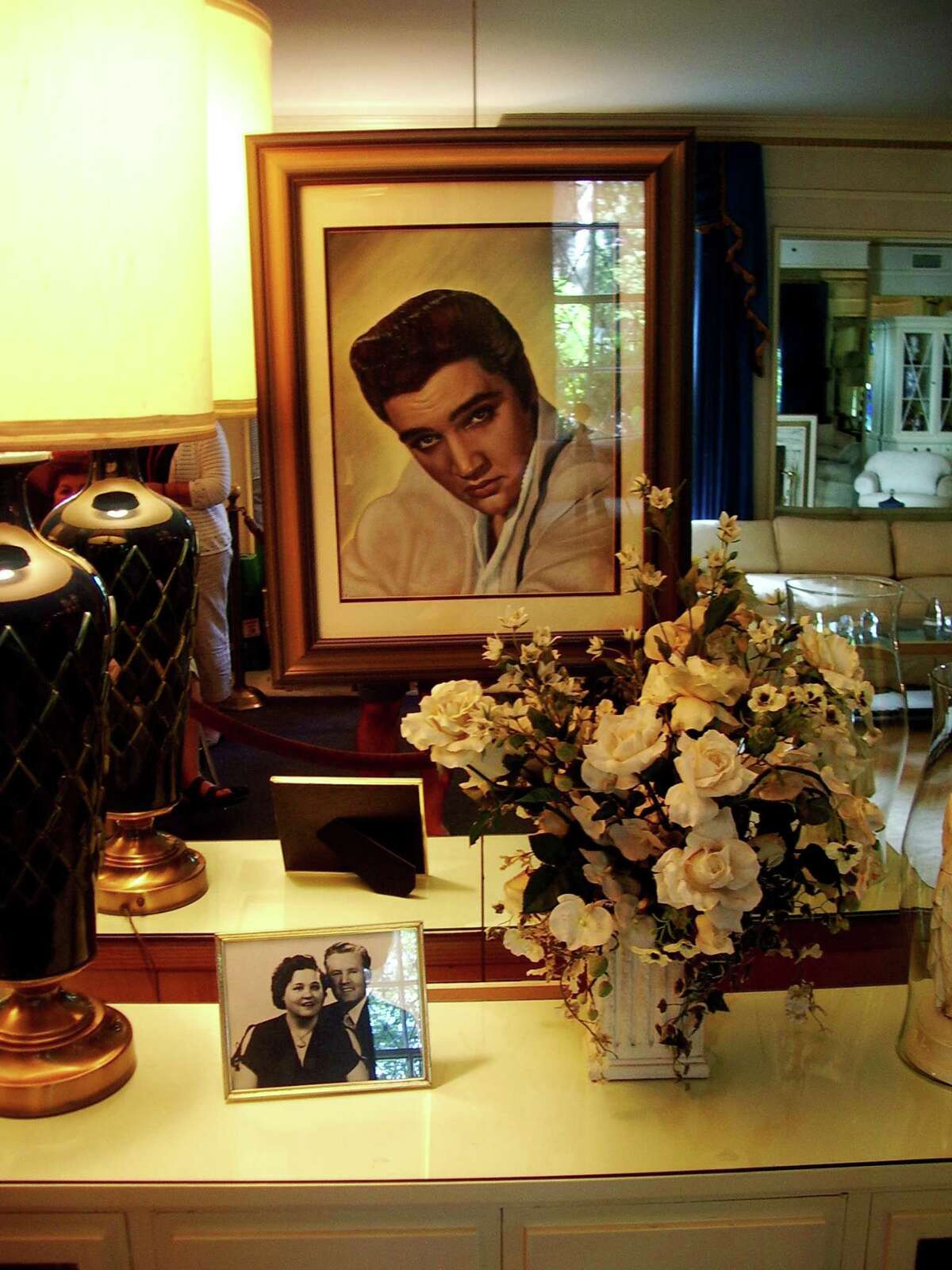 A portrait of Elvis Presley inside Graceland, his home in Memphis, Tenn. In the foreground is a photo of his parents, Gladys and Vernon Presley.