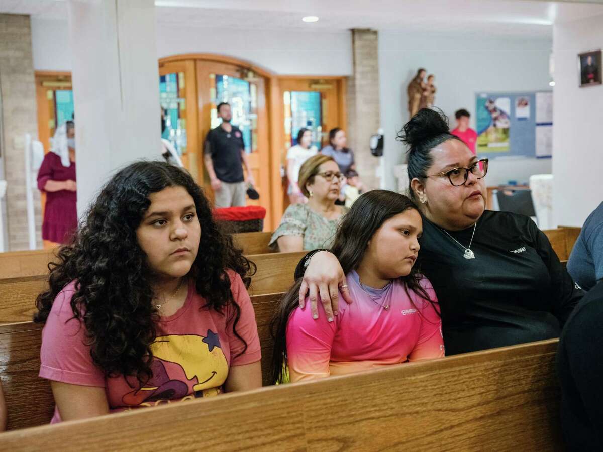 Mireyah Chavez, 10, center, a student at Robb Elementary School who was present during the shooting, is comforted during a prayer vigil at Sacred Heart Catholic Church in Uvalde, Texas, on Tuesday night, May 24, 2022. Harrowing details began to emerge Wednesday of the massacre inside a Texas elementary school, as anguished families learned whether their children were among those killed by an 18-year-old gunman?•s rampage in the city of Uvalde hours earlier. (Christopher Lee/The New York Times)