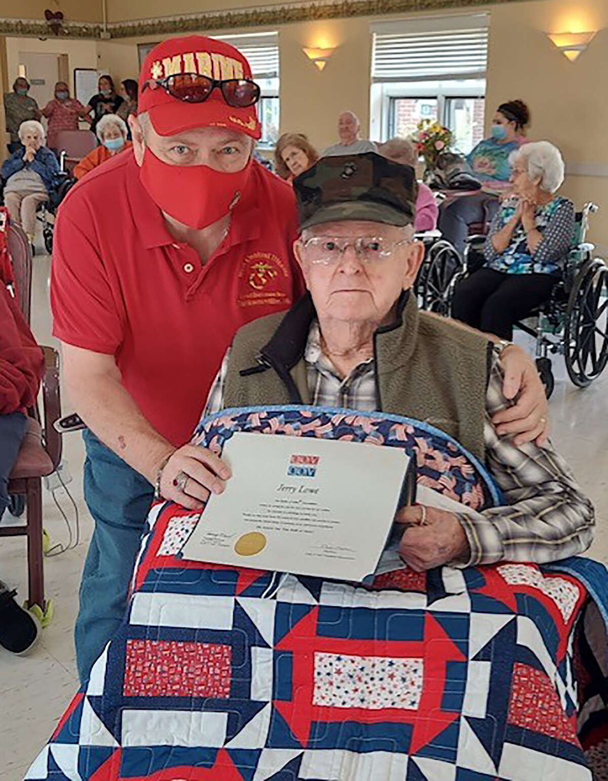 Jerry Lowe receives a Quilt of Valor from Rick Howland of West Central Illinois Marines Corps League No. 1177. Lowe is a World War II veteran and survivor of the Battle of Iwo Jima. Handmade Quilts of Valor are awarded as a source of comfort and healing to American military service members and veterans who have been touched by war. According to the Quilts of Valor Foundation, more than 302,712 quilts have been presented since the effort began in 2003.
