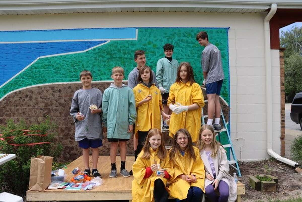 Students from Onekama Consolidated Schools pose for a photo in front of the garden mural they are working on at the Farr Center. Pictured are (front row, from left) Zaria, Hazel and Anna; (middle row) James, Bennett, Brickston and Danika; and (back row) Reznor, Garrett and Arden.