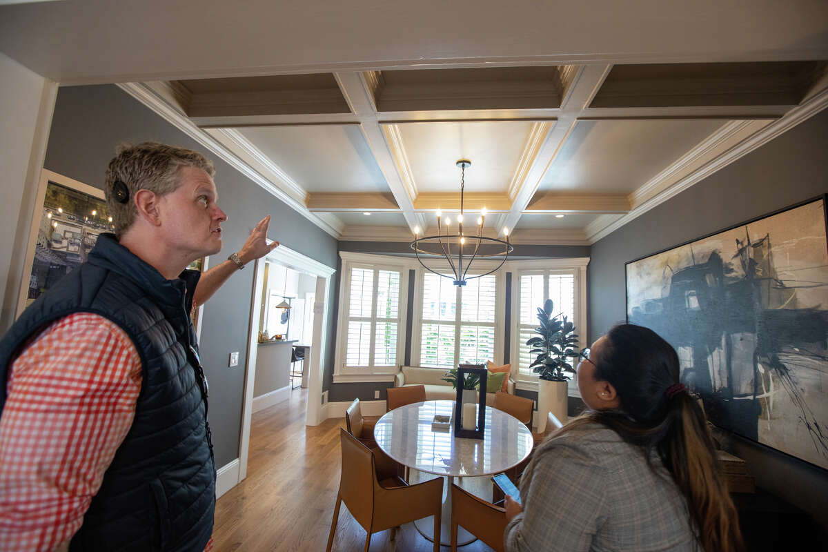 SFGATE columnist Drew Magary (left) inspects the ceiling at 231 12th Avenue, a house for sale in San Francisco, Calif. on May 24, 2022. He is inspecting the state of the real estate market in San Francisco.