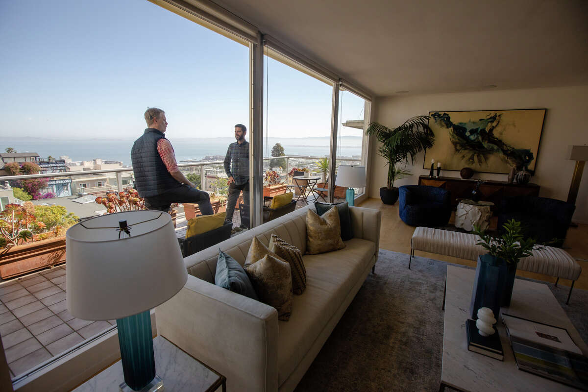 SFGATE columnist Drew Magary, left, is shown around by real estate agent Paul Hatvany Kitchen the condo 1160 Greenwich St., No. 300, which is for sale in San Francisco on May 24, 2022. Magary is inspecting the state of the real estate market in San Francisco.