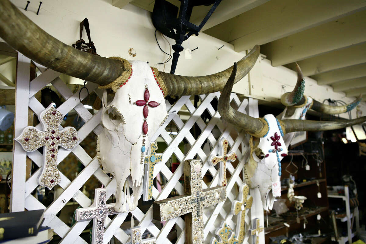Bull horns, skulls, and a cross are displayed among a variety of items at a store in Texas.