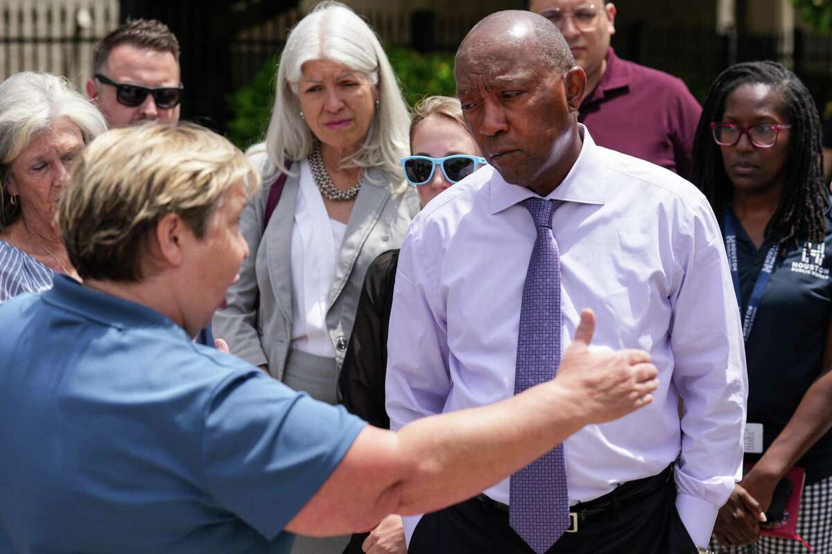 Mayor Sylvester Turner talks to Karry Davis Mader, left, as he speaks with Heights area residents while taking a closer look at 11th Street, after plans to change traffic patterns on the street, including adding a bicycle lane, that drew some alarm from residents Wednesday, May 25, 2022 in Houston. Area residents near 11th fear taking away a lane for vehicles will create traffic problems, which will spill onto residential streets nearby. They argue minimal changes can achieve the same safety benefits.