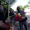 A police officer takes flowers from a resident to be placed at a makeshift memorial outside Robb Elementary School in Uvalde, Texas, May 25, 2022.