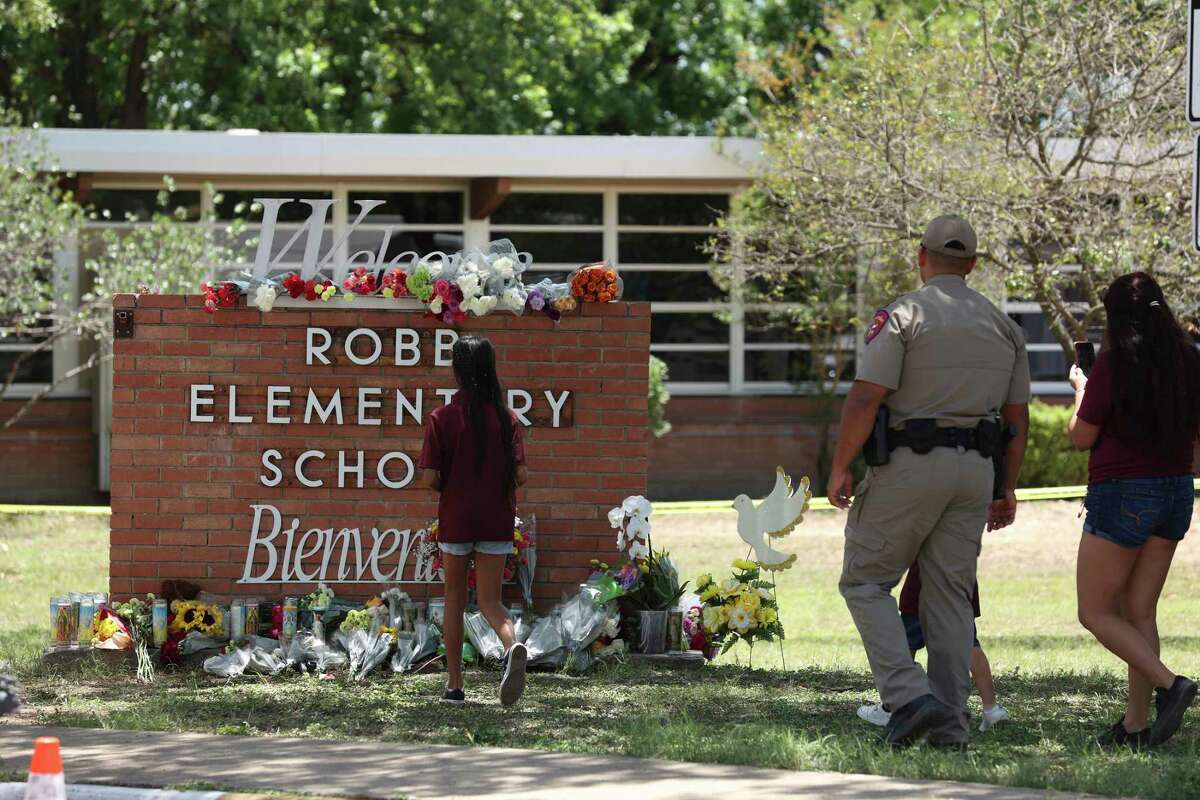 Families leave flowers by a memorial at Robb Elementary School in Uvalde, Texas, Wednesday, May 25, 2022. On Tuesday, 18-year-old Salvador Ramos entered the school and killed 19 children and two adults.
