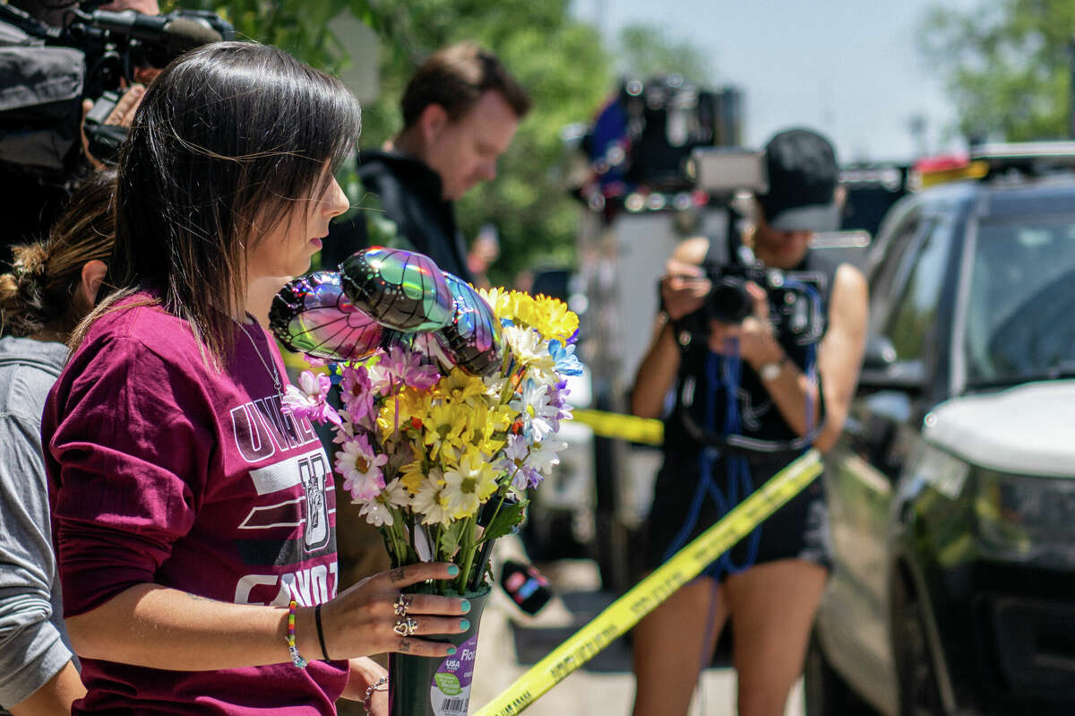 UVALDE, TEXAS - MAY 25: Community member Amanda Welch brings flowers to lay at Robb Elementary School on May 25, 2022 in Uvalde, Texas. According to reports, during the mass shooting, 19 students and 2 adults were killed, with the gunman fatally shot by law enforcement. (Photo by Brandon Bell/Getty Images)
