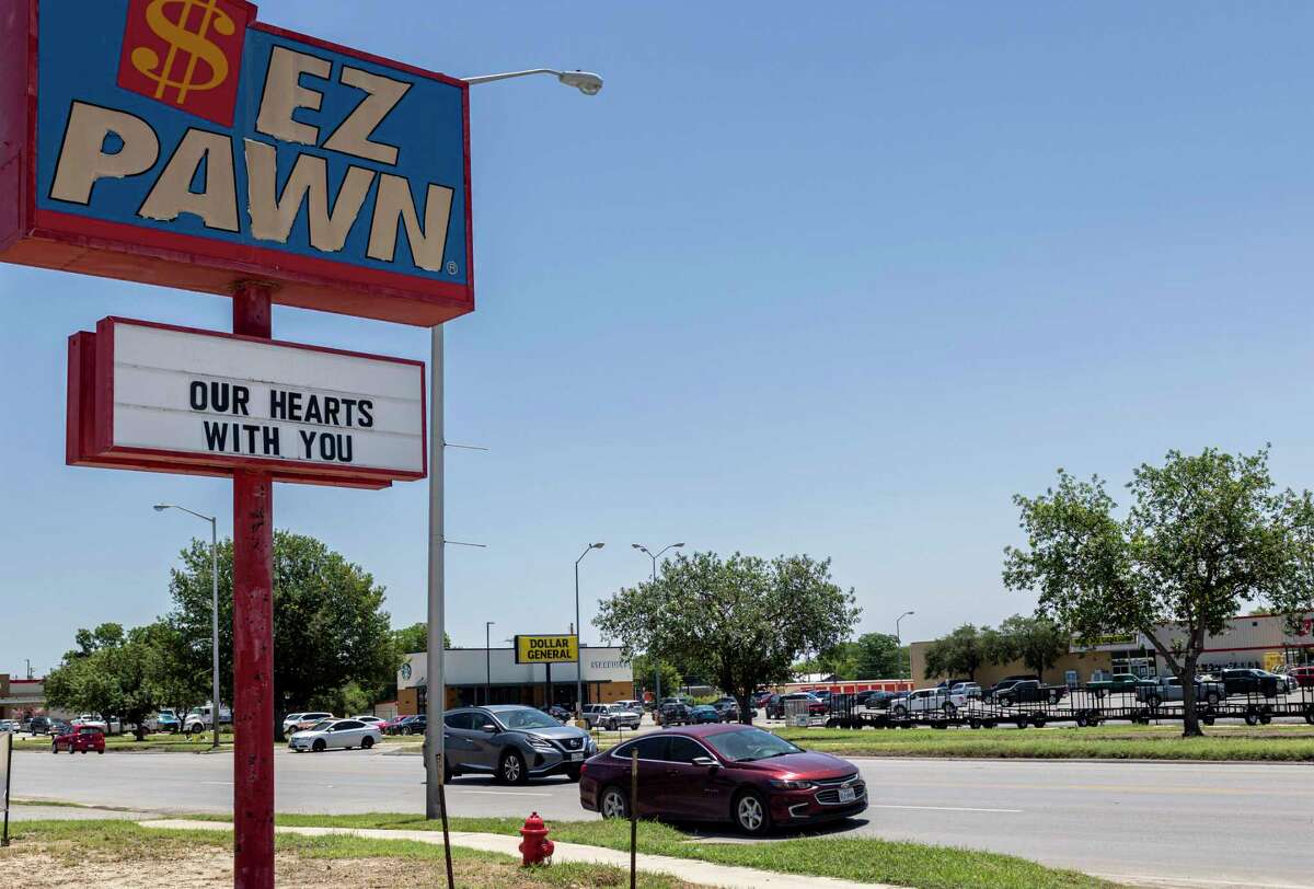 A sign outside a pawn shop reads “Our heart are with you” along Main Street in Uvalde, Texas, on May 25, 2022. On Tuesday, an 18-year-old suspect opened fire at Robb Elementary School and killed at least 19 students and two teachers.