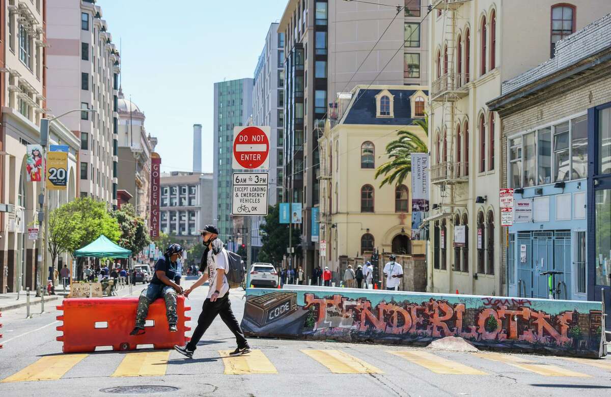 Angel Feaster (left) watches as people cross Golden Gate Avenue in San Francisco. St. Anthony Foundation is leading an effort to turn a block of Golden Gate Ave in the Tenderloin into a “greenway” with a play area for kids and seating area for residents.