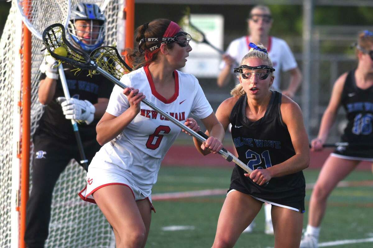 New Canaan’s Kaleigh Harden carries the ball while defended by Darien’s Kaci Benoit during the FCIAC girls lacrosse championship on Wednesday in Norwalk.