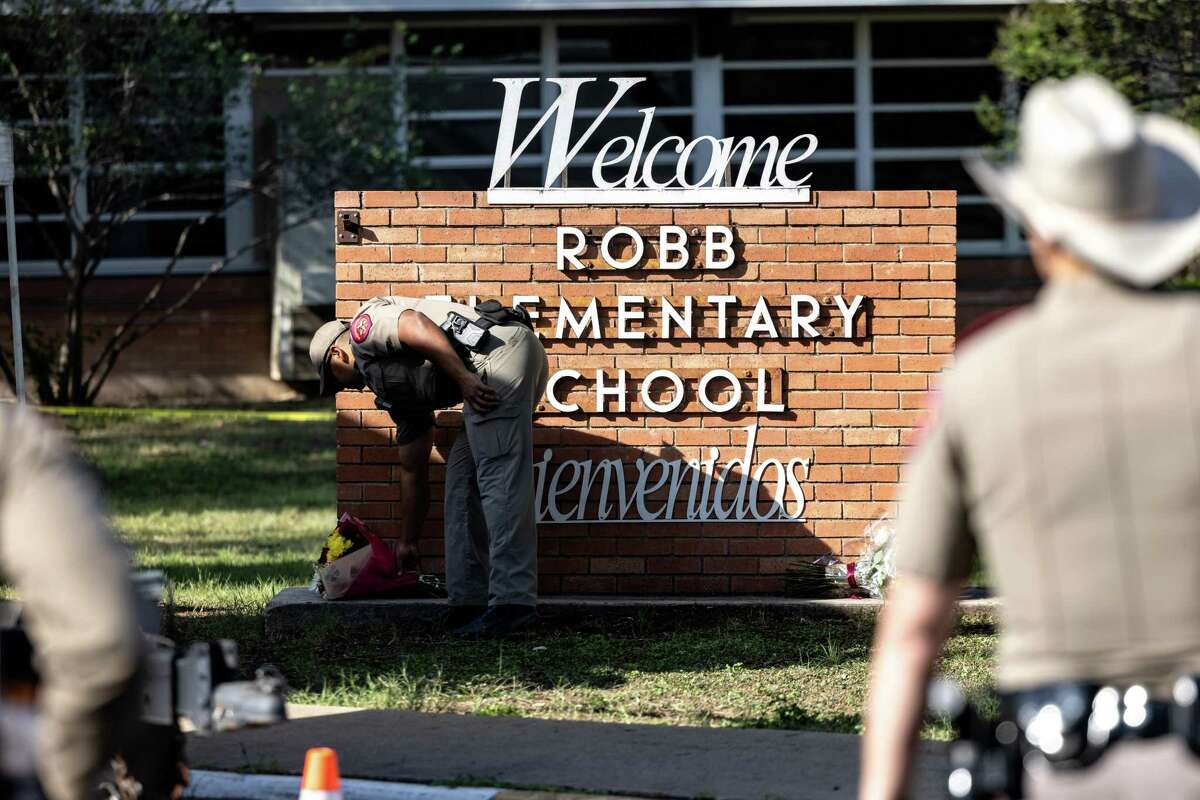 Un oficial de la policía estatal de Texas recibe flores para las víctimas de la masacre perpetrada ayer en la escuela Robb Elementary School donde fallecieron 21 personas, incluyendo 19 niños el 25 de mayo de 2022.