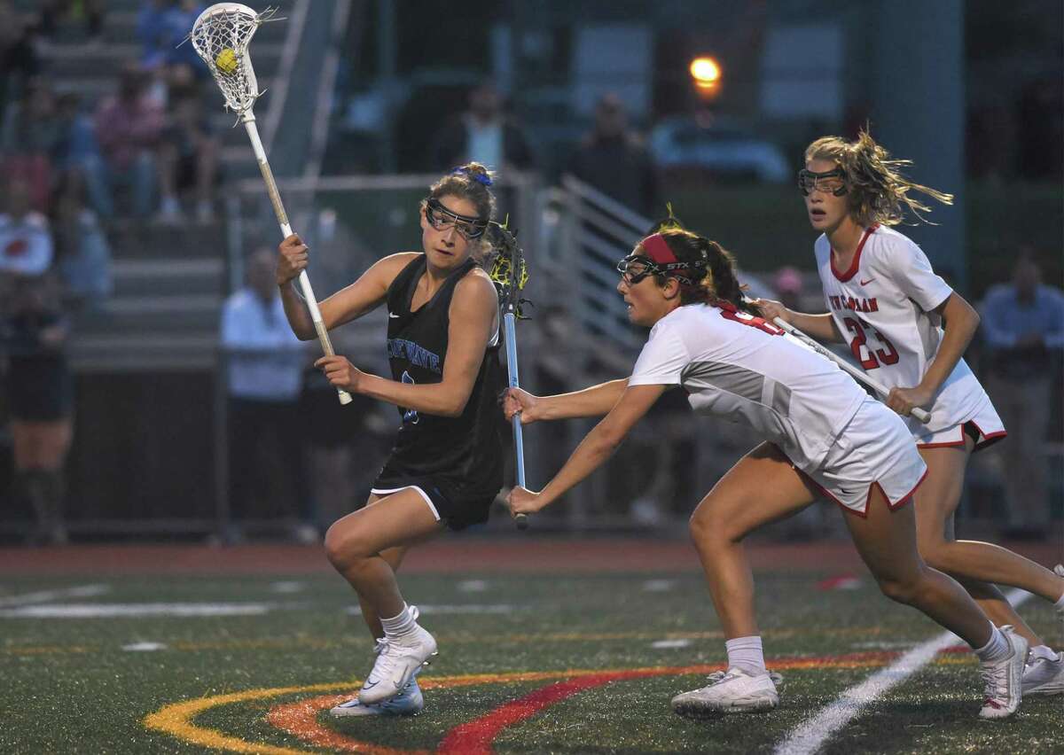 Darien's Ceci Stein (9) battles New Canaan's Kaleigh Harden during the FCIAC girls lacrosse final in Norwalk on Wednesday, May 25, 2022.