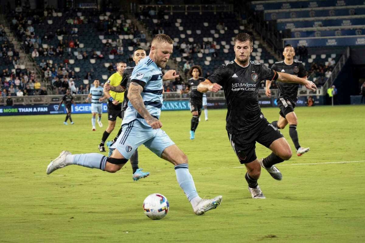 Sporting Kansas City forward Johnny Russell crosses the ball late in the second half against the Houston Dynamo during a Lamar Hunt U.S. Open Cup soccer match Wednesday, May 25, 2022, in Kansas City, Kan. (Luke Johnson/The Kansas City Star via AP)