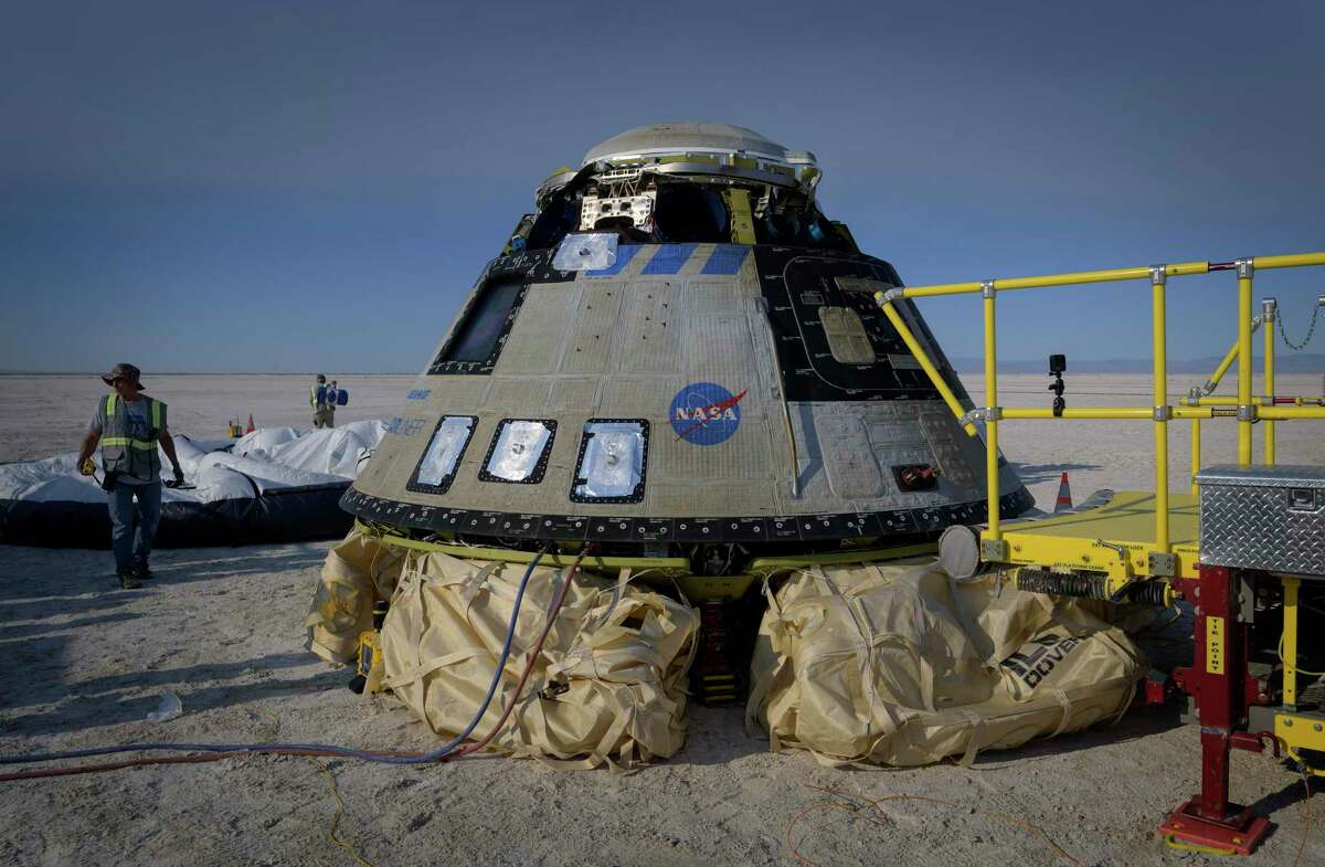 Boeing and NASA teams work around Boeing's CST-100 Starliner spacecraft after it landed at White Sands Missile Range's Space Harbor, Wednesday, May 25, 2022, in New Mexico. (Bill Ingalls/NASA via AP)