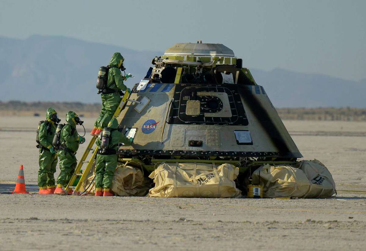 Boeing and NASA teams work around Boeing's CST-100 Starliner spacecraft after it landed at White Sands Missile Range’s Space Harbor, Wednesday, May 25, 2022, in New Mexico. (Bill Ingalls/NASA via AP)