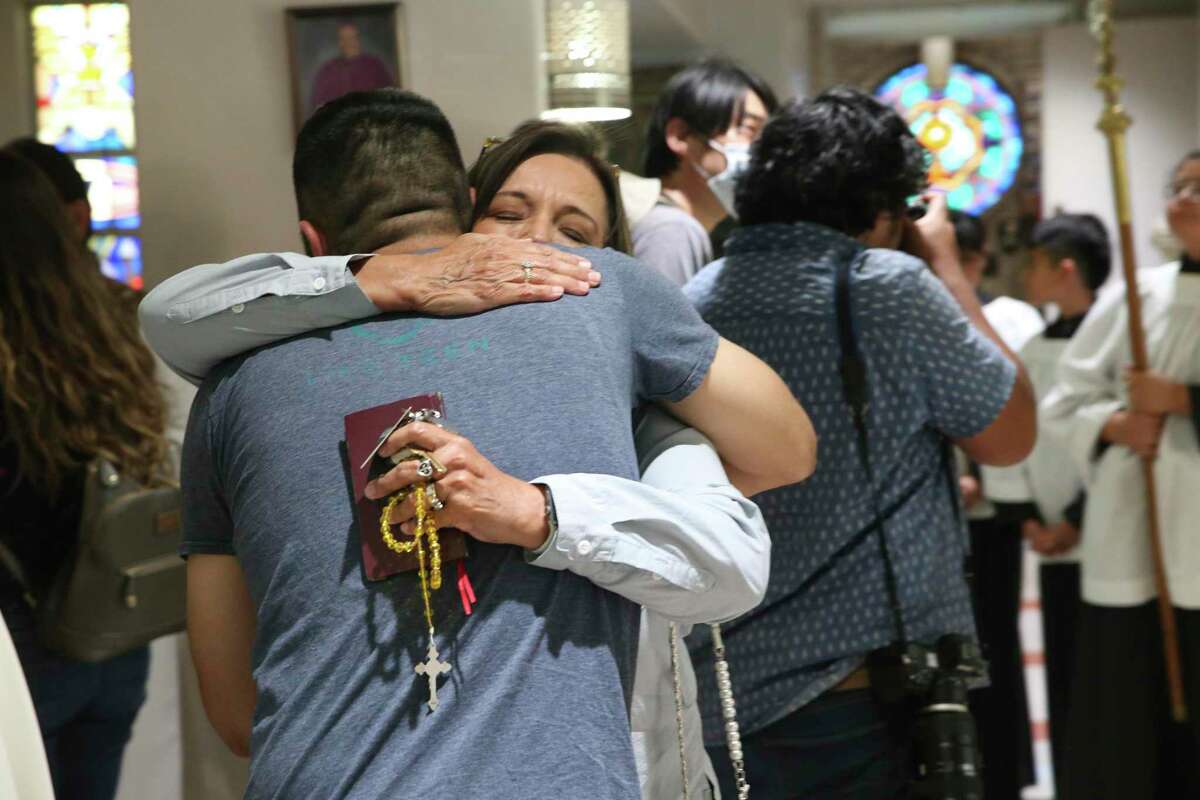 People hug as they arrive for a Mass for victims of the Robb Elementary School shooting at Sacred Heart Church in Uvalde, Texas, Wednesday, May 25, 2022.