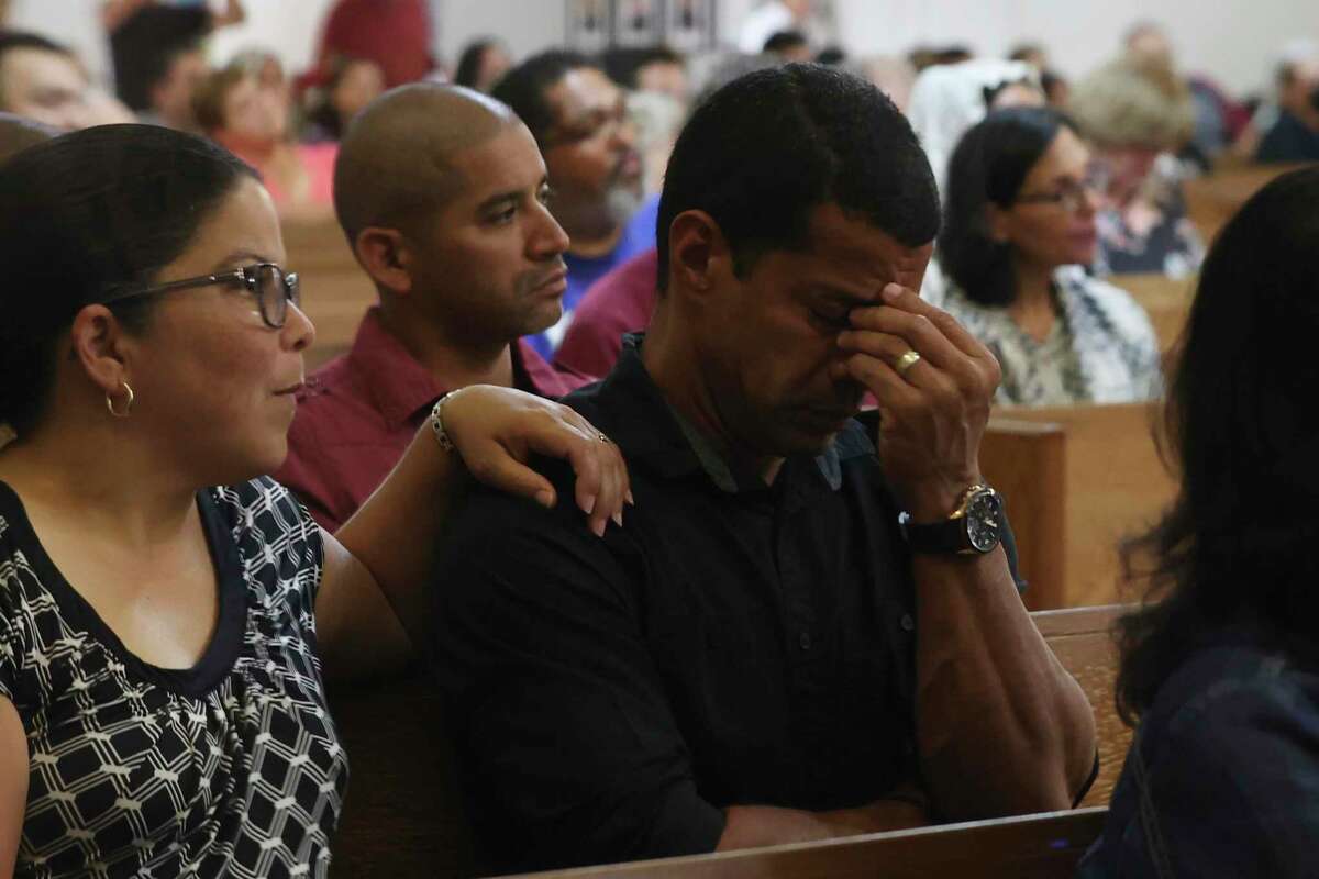 People react during a Mass for victims of the Robb Elementary School shooting at Sacred Heart Church in Uvalde, Texas, Wednesday, May 25, 2022.