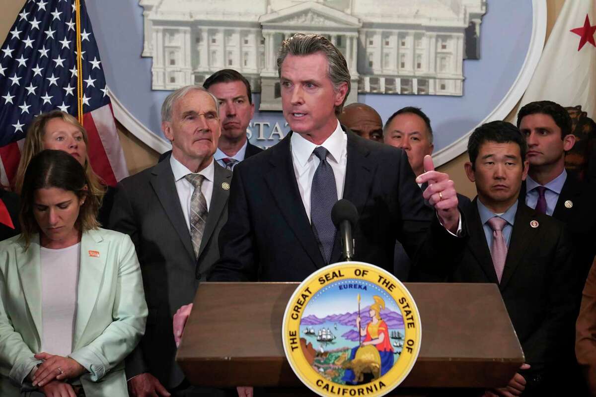 Gov. Gavin Newsom discusses the recent mass shooting in Texas flanked by lawmakers from both houses of the California Legislature during a news conference in Sacramento on Wednesday. Newsom said he is ready to sign more restrictive gun measures passed by lawmakers.
