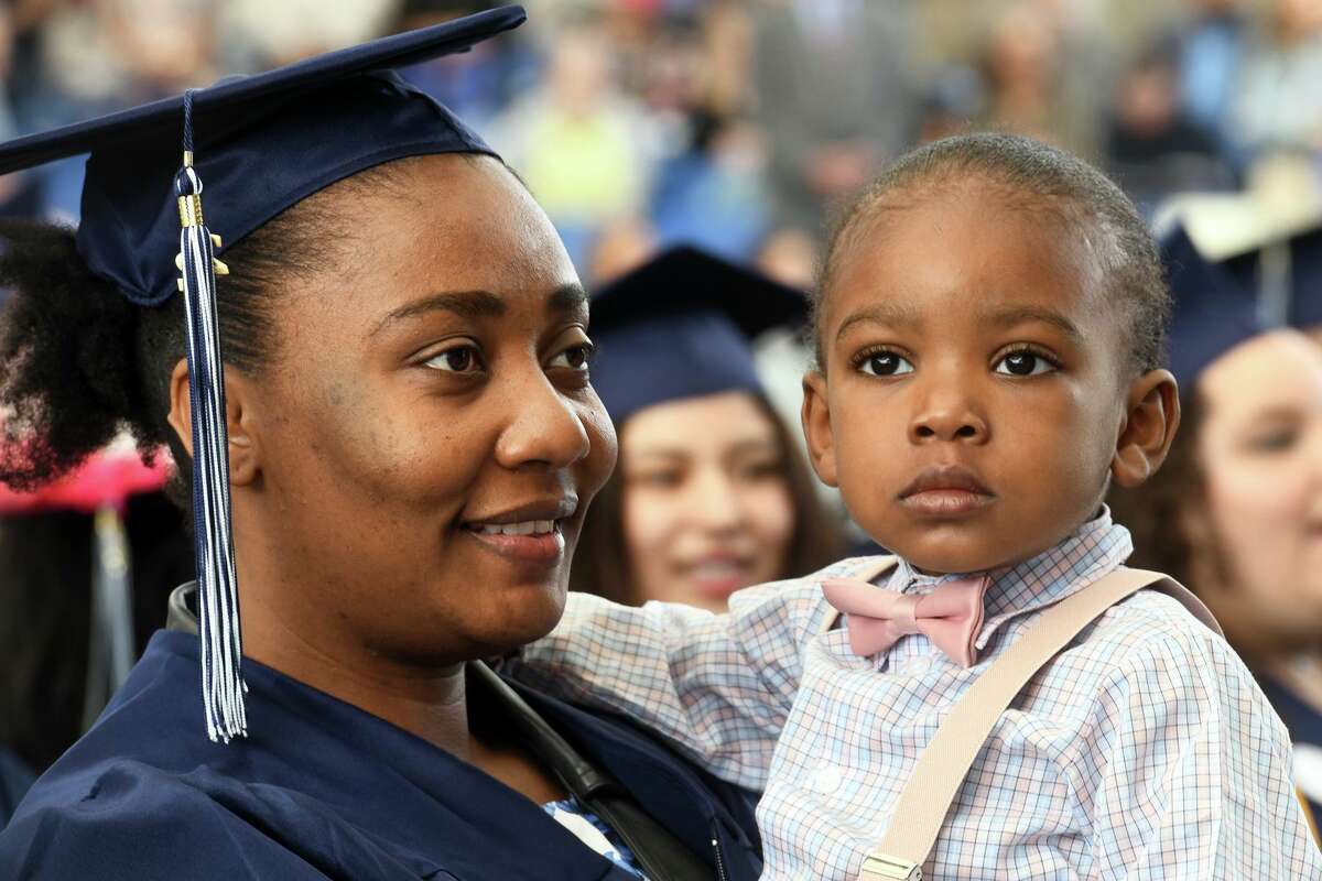 Massa Pierre Noel, a Health Career Pathways graduate from Bridgeport, sits with her son, Favor, during Commencement for the Housatonic Community College Class of 2022, held at the Hartford Healthcare Amphitheater in Bridgeport, Conn. May 26, 2022.