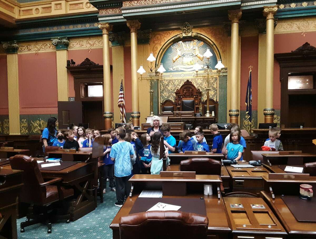State Rep. Annette Glenn, center, talks with third-grade students from Adams Elementary in Midland in the House chamber during their tour of the Capitol in Lansing on May 25.