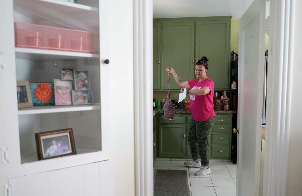 Carie Mathis checks the time before leaving for work as a house cleaner. After coronavirus lockdowns shuttered her business in March 2020, she and her children received an eviction notice at their Rodeo home of four years. Now, after dealing with long unemployment delays and living for a stretch in her parents’ garage, she and her 17-year-old children are facing a third move in two years.