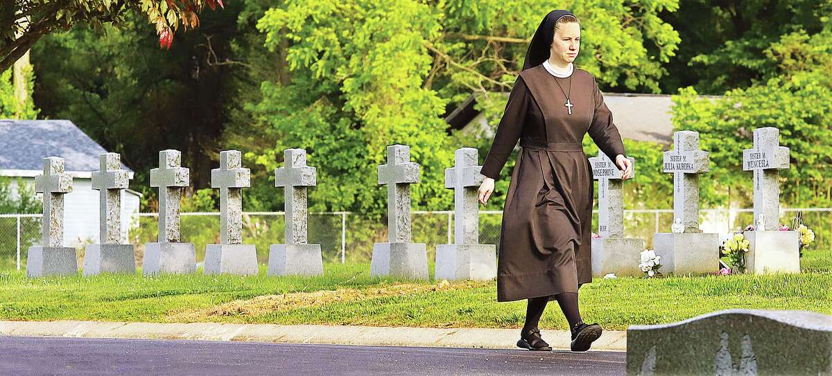 John Badman|The Telegraph A sister from the convent of the Sisters of St. Francis of the Martyr St. George in Alton goes for a walk through St. Joseph Cemetery in Alton this week. The paved roads of the cemetery, located near the convent, are a popular place for sisters to walk in peace for reflection and exercise.