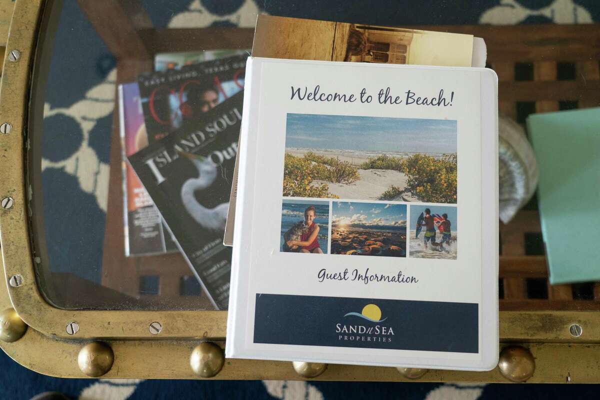 A welcome booklet sits on a coffee table inside a Sand ’N Sea Properties beach house rental, Wednesday, May 25, 2022, in Galveston.