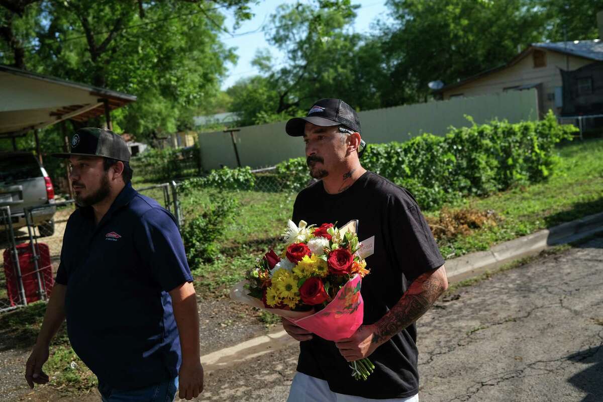 People take flowers to place outside Robb Elementary School on May 25 in Uvalde, Texas.