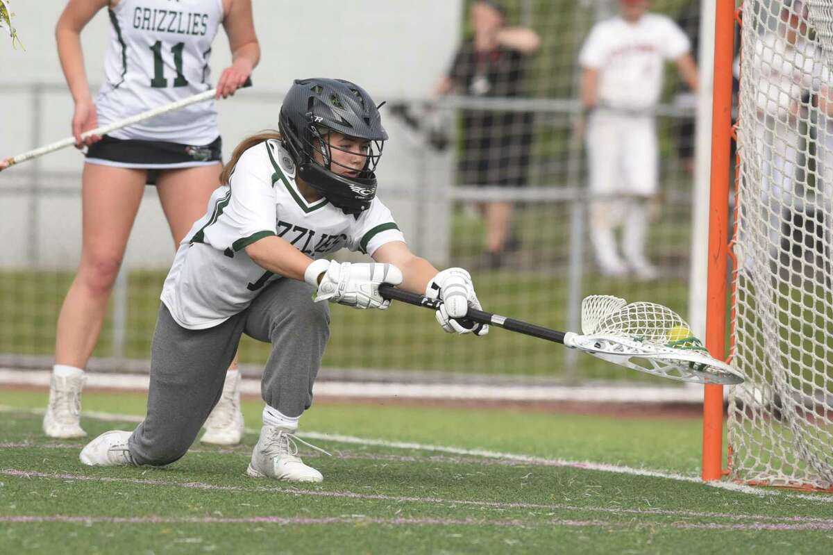 Guilford goalie Sydney Widlitz reaches back to corral the ball during the SCC girls lacrosse championship against Cheshire on Thursday at Ken Strong Stadium in West Haven.