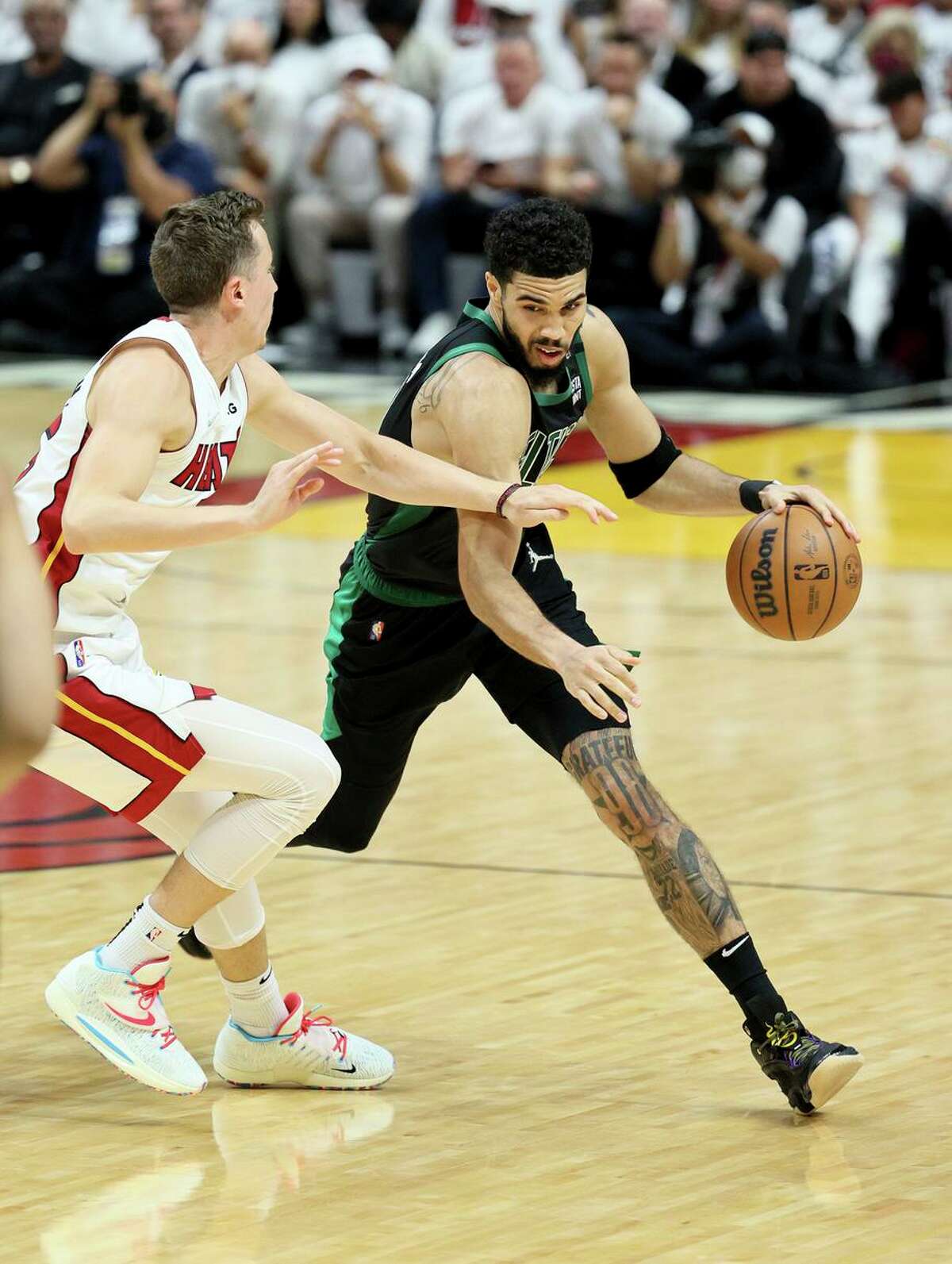MIAMI, FLORIDA - MAY 25: Jayson Tatum #0 of the Boston Celtics drives the ball against Duncan Robinson #55 of the Miami Heat in Game Five of the 2022 NBA Playoffs Eastern Conference Finals at FTX Arena on May 25, 2022 in Miami, Florida. NOTE TO USER: User expressly acknowledges and agrees that, by downloading and or using this photograph, User is consenting to the terms and conditions of the Getty Images License Agreement. (Photo by Andy Lyons/Getty Images)
