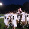 Weston's boys lacrosse team celebrates with the SWC championship banner after an 11-2 win over New Milford at Blue and Gold Stadium in Newtown, Conn., on May 26, 2022.