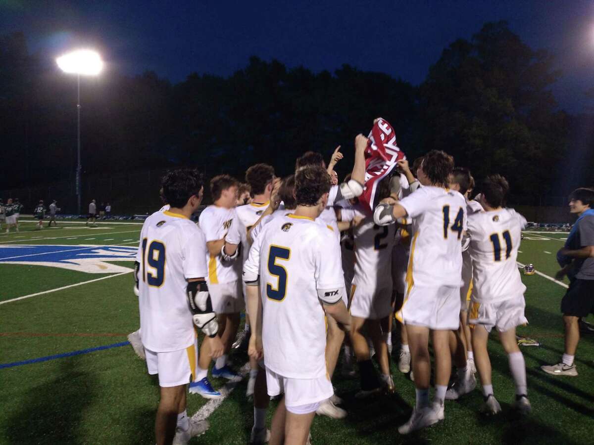Weston's boys lacrosse team celebrates with the SWC championship banner after an 11-2 win over New Milford at Blue and Gold Stadium in Newtown, Conn., on May 26, 2022.