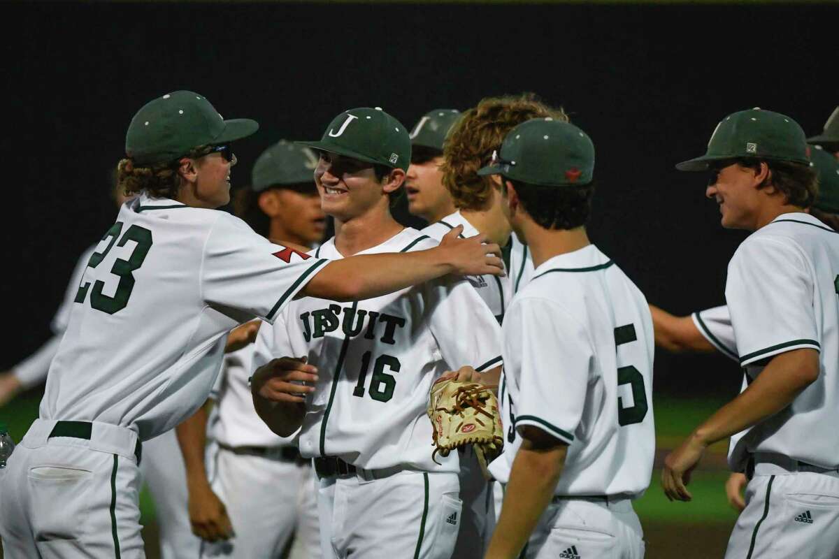Teammates surround Strake Jesuit’s Garrett Stratton (16) after winning game 1 of the Region III-6A semifinal abasing Katy Thursday, May 26, 2022, in Jersey Village, Texas.