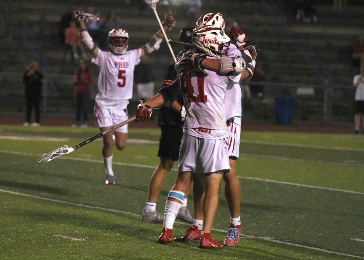 Fairfield Prep’s Peter Grandolfo (41) and Marco Firmender (42) embrace after a fourth-quarter goal against Cheshire in the SCC boys lacrosse championship at Ken Strong Stadium in West Haven on Thursday. Fairfield Prep’s Luke Shannehan (5) also celebrates.