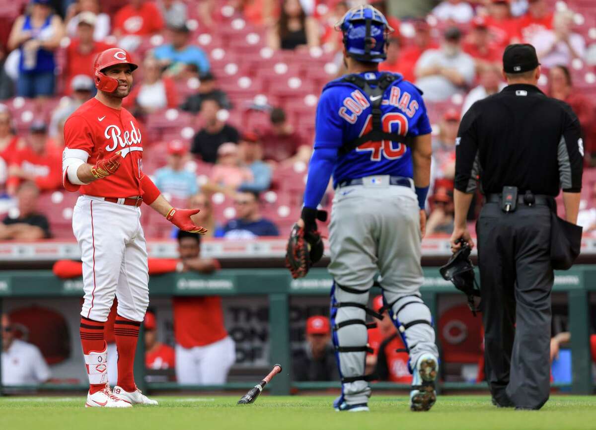 Reds first baseman Joey Votto (left) exchanges words with Cubs catcher Willson Contreras after striking out during the seventh inning of the Reds’ 20-5 win in Cincinnati.