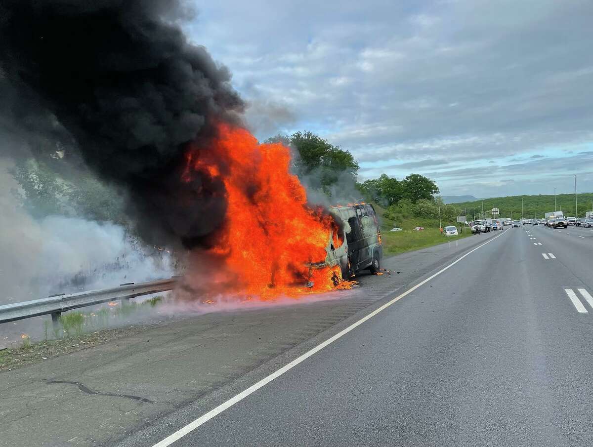 Cheshire volunteer firefighters extinguished a burning vehicle and brush fire Thursday on Interstate 84 West, according to the department.