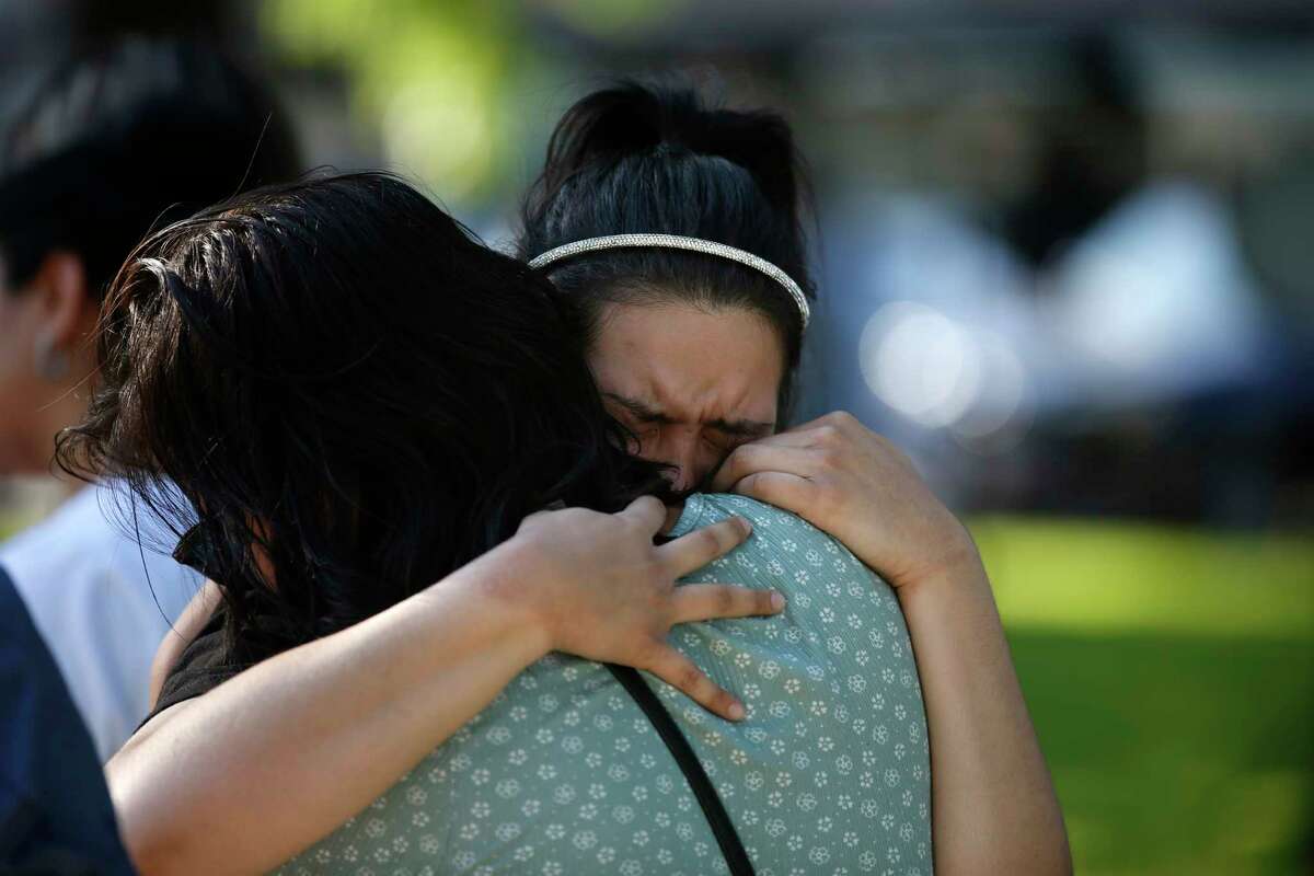 Prianna Ayala weeps as she is embraced at a memorial site for the victims killed in this week's elementary school shooting in Uvalde, Texas, Thursday, May 26, 2022.
