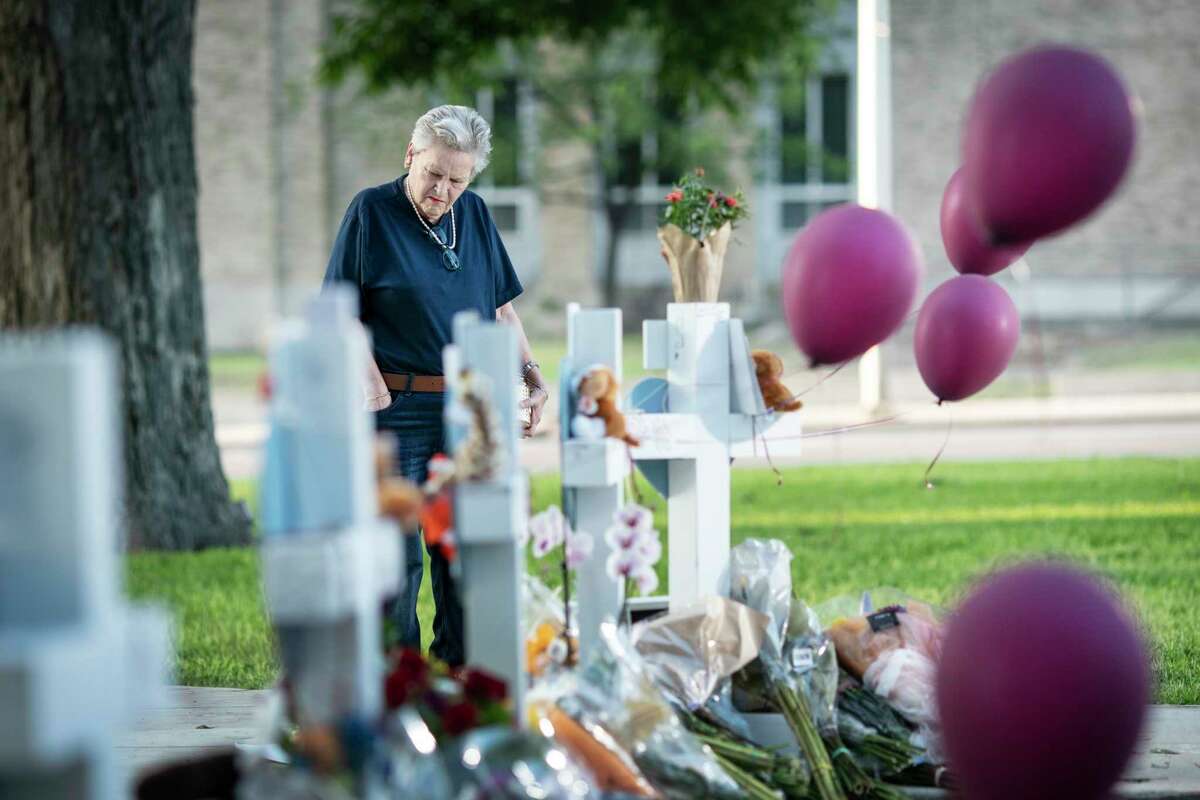 Eloise Castro, 75 a resident of Uvalde visits a memorial site to lay flowers and a candle in the town square for the victims killed in this week's elementary school shooting on Friday, May 27, 2022, in Uvalde, Texas.