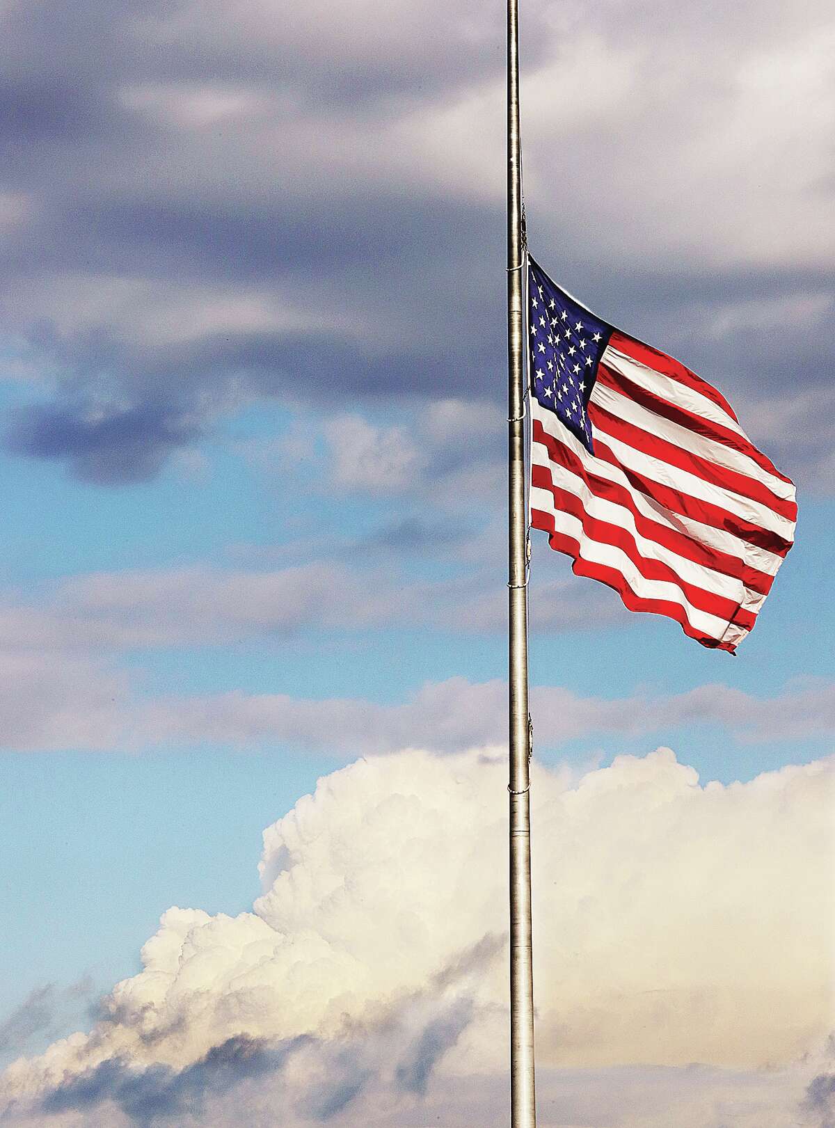 The large American flag at Roberts Motors on Alby Street in Alton, was at half staff Thursday, flapping in a steady breeze. Many flags in the area have been lowered in honor of the 19 students and two adults killed this week in the elementary school shooting in Uvalde, Texas.