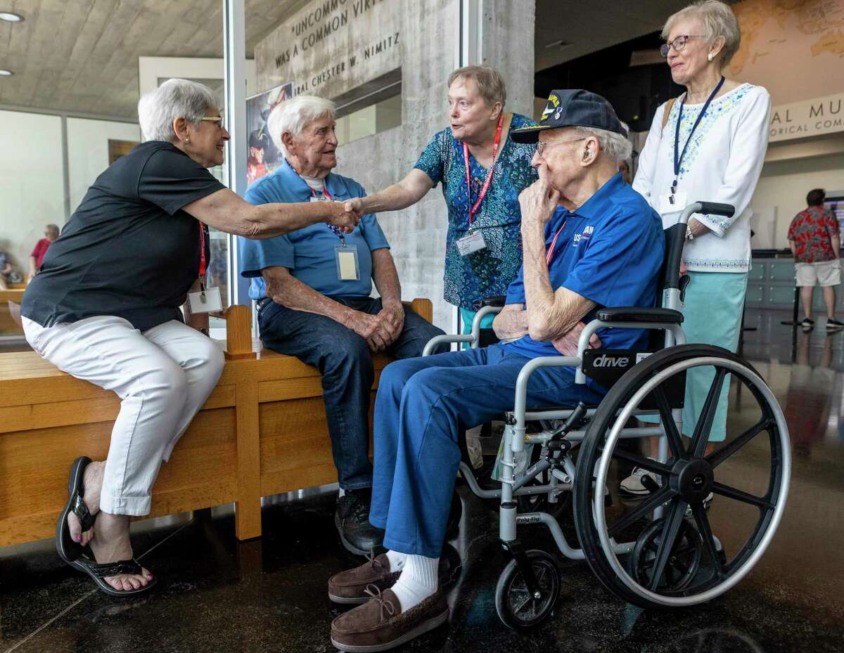 Family members of USS Indianapolis survivors Harold Bray, Jr., second from left, and Cleatus Lebow, second from right, greet each other during a 2022 reunion of the USS Indianapolis Legacy Organization in Fredericksburg. Bray and Lebow are the last two surviving crew members of the USS Indianapolis which was sunk July 30, 1945 after being struck by two Japanese torpedoes.