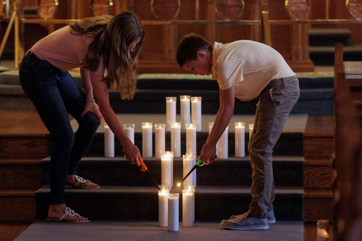 Children light candles as the names of each victim of the Robb Elementary School massacre are read aloud at an evening prayer service at St. Philip’s Episcopal Church in Uvalde on Thursday.