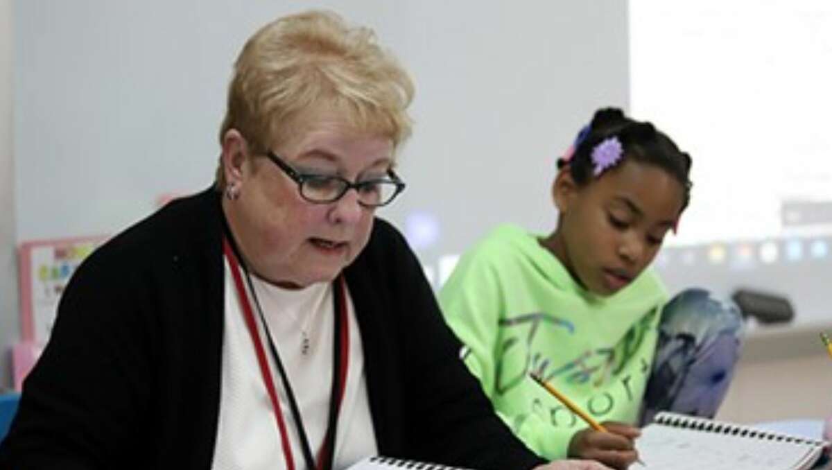 Mary Ruth Snelson works with a student at Frohardt 3-4 Education Center in Granite City. On Thursday she recorded 50 years of service to Granite City schools.