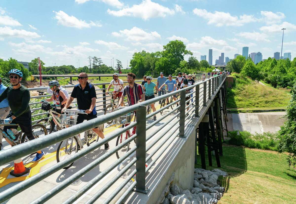 People cross the M-K-T Trail Bridge during a reopening ceremony, Friday, May 27, 2022, in Houston.