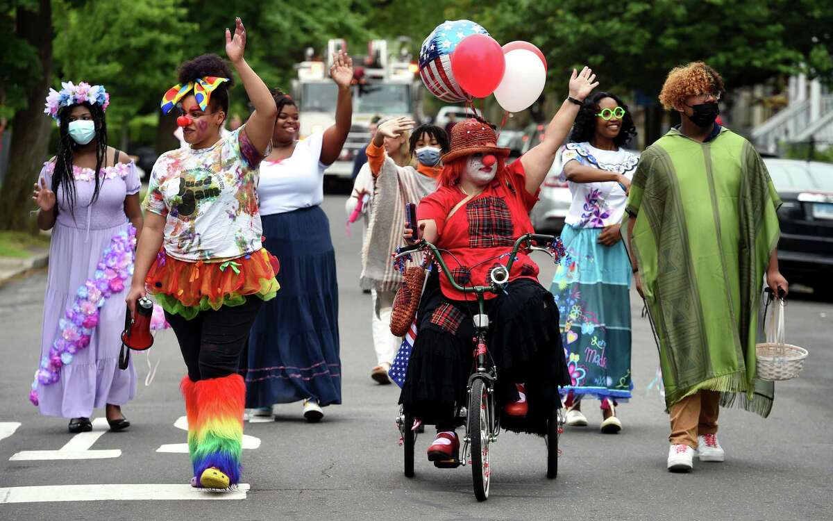 A contingent of clowns makes their way along Atwater Street during the 14th annual Fair Haven Community Parade in New Haven Friday.