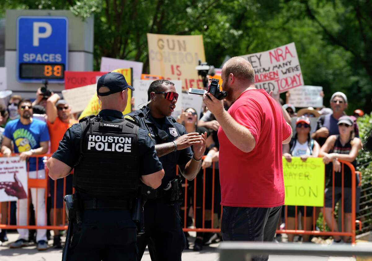 Houston Police officers confront a man who attempted to disrupt a protest at Discovery Green outside of the NRA Convention at the George R. Brown Convention Center on Friday, May 27, 2022 in Houston.